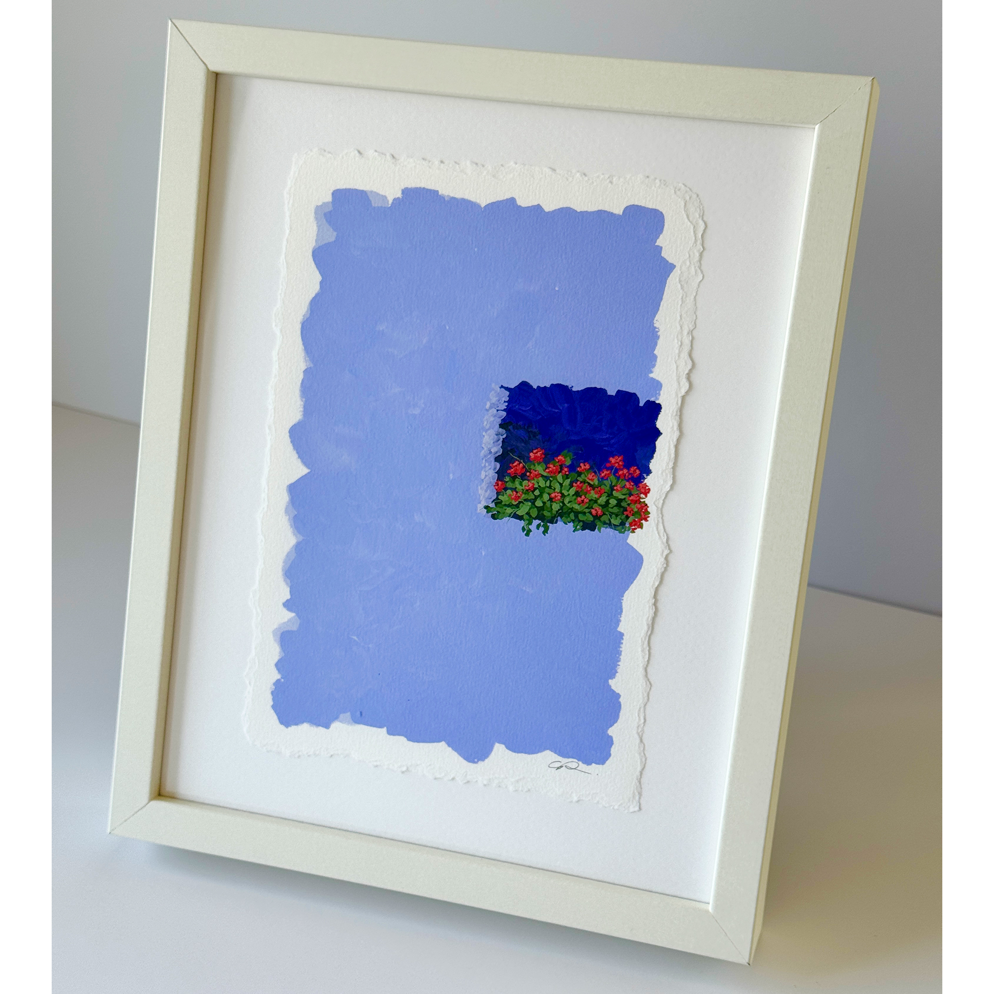 A deep, romantic periwinkle background. A wall of a colourful building and a balcony of romantic red flowers standing out on the ledge.