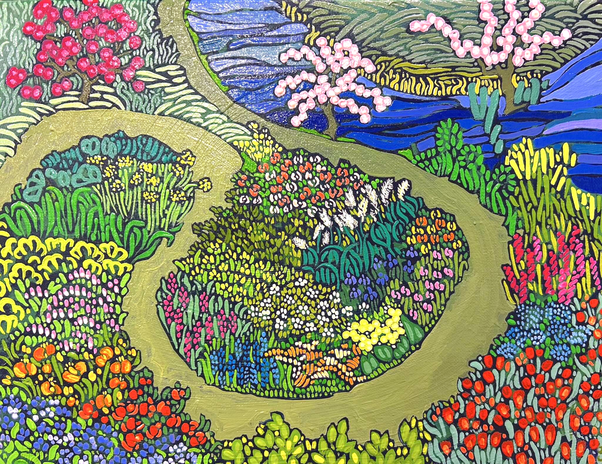 Aerial view of a bright pattern of tiny flowers in a roadside garden beside a curving brown road
